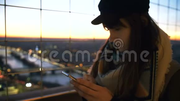 特写年轻美丽优雅的旅行者女性使用手机应用程序在玻璃墙与史诗波克日落视图慢动作视频的预览图