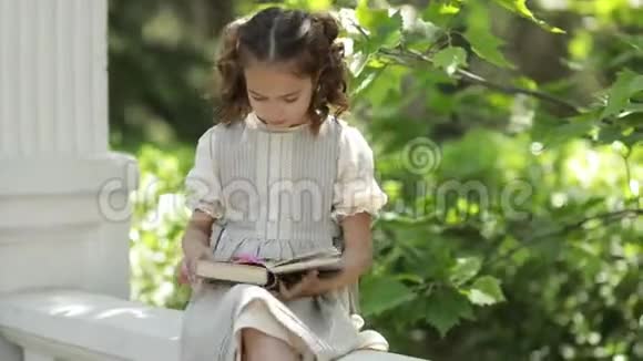 一个穿着校服的女孩坐在具体的台阶上看书视频的预览图