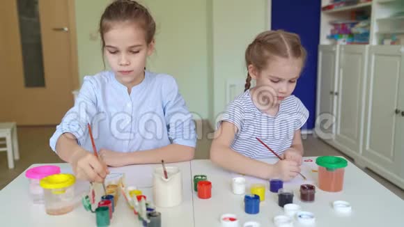 小女孩用画笔和颜料画画视频的预览图