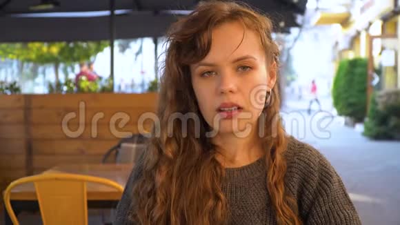 年轻女子在街头咖啡馆吃巧克力蛋糕特写视频的预览图
