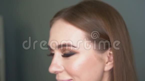 化妆师用画笔进行面部矫正闪亮的眼睛闪光的视频的预览图
