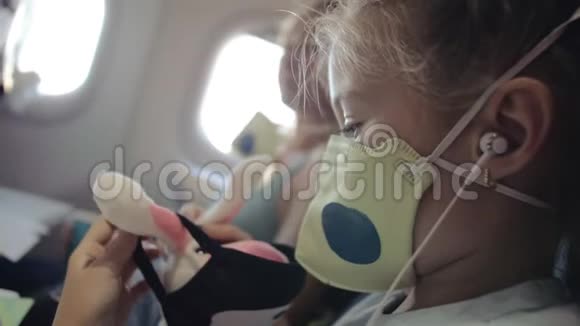 小女孩白种人在飞机上戴着防护面罩带呼吸器的飞机上的儿童婴儿游客视频的预览图