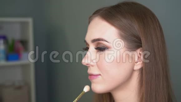 化妆师用画笔进行面部矫正闪亮的眼睛闪闪发光视频的预览图