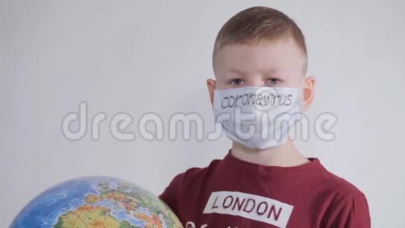 男孩拥有一个地球仪一个地球的模型孩子拿着一个牌子上面写着COVID19孩子很小心视频的预览图