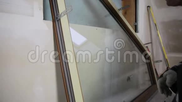 汉德曼建筑工人在一个新的绝缘和填充干燥的墙壁阁楼安装PVC窗户视频的预览图