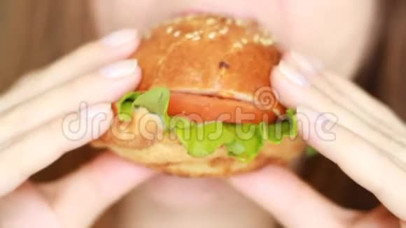 快餐厅年轻的饥饿女人咬纯素汉堡视频的预览图