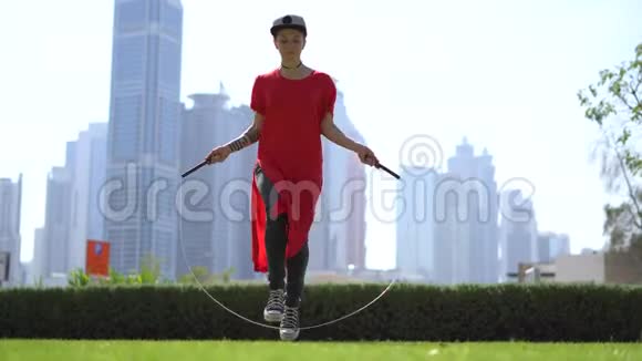 年轻女孩跳着跳绳背景是迪拜的城市景观视频的预览图