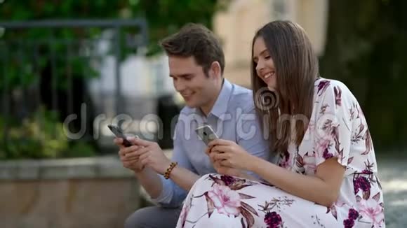快乐的一对夫妇花时间在户外使用智能手机视频的预览图