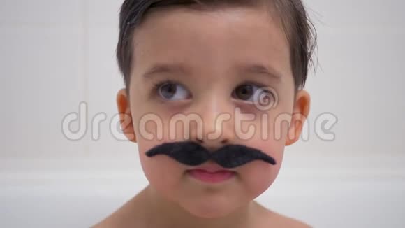 一个留着黑胡子的小男孩坐在浴室里视频的预览图