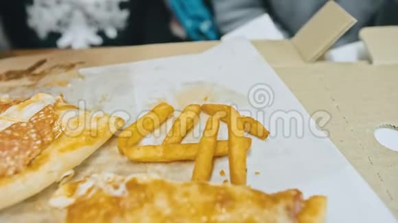 孩子吃比萨饼和炸土豆在户外餐馆里一群年轻的女孩子在吃披萨和咀嚼视频的预览图