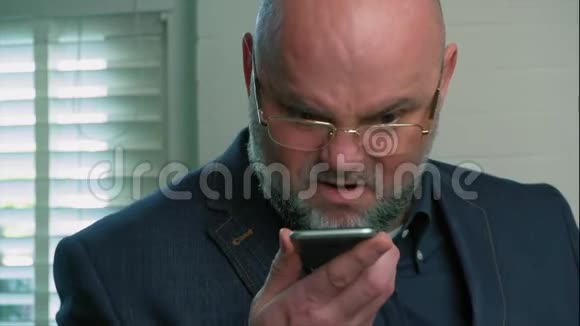 愤怒的情绪激动的男人对着对话者在智能手机上交谈视频的预览图