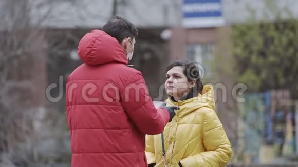 一位年轻的欧洲人在户外给他的女朋友戴上一次性医用口罩新冠状病毒视频的预览图
