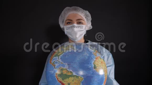 穿着防护服的女人拿着一个牌子上面写着covid19女孩拿着一个地球模型一个地球仪视频的预览图