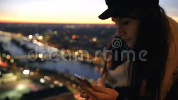 美丽的年轻白种人博客女性打字智能手机信息在惊人的bokeh日落城市河景慢动作视频的预览图