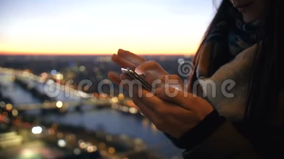 近距离年轻的商务女性使用智能手机信使在玻璃墙与惊人的博克日落河景观慢动作视频的预览图