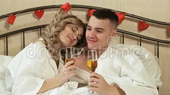 年轻情侣在床上喝香槟视频的预览图