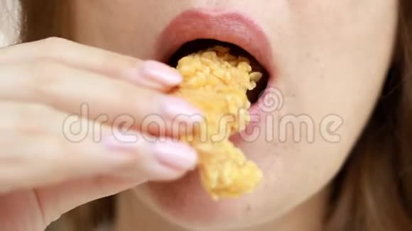 闭上母嘴吃金块女人在咖啡馆里吃快餐鸡块翅膀视频的预览图