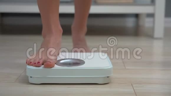 早上在浴室秤上检查体重的成年女性视频的预览图