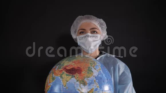 穿着防护服的女人拿着一个牌子上面写着covid19女孩拿着一个地球模型一个地球仪视频的预览图