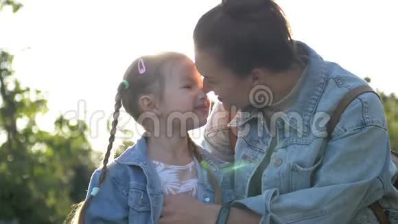 幸福的家庭妈妈和孩子在公园的户外玩得很开心可爱的女孩在玩拥抱和亲吻她的母亲视频的预览图