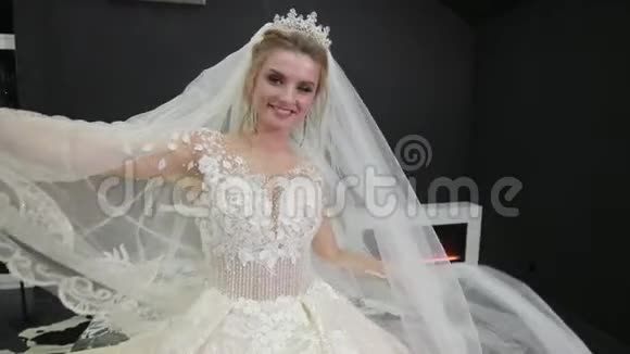 美丽的新娘穿着白色连衣裙玩着面纱微笑着用手挥手视频的预览图