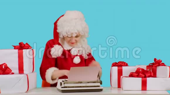 有趣的圣诞女人圣诞老人用机械打字机致贺祝圣诞快乐新年快乐视频的预览图
