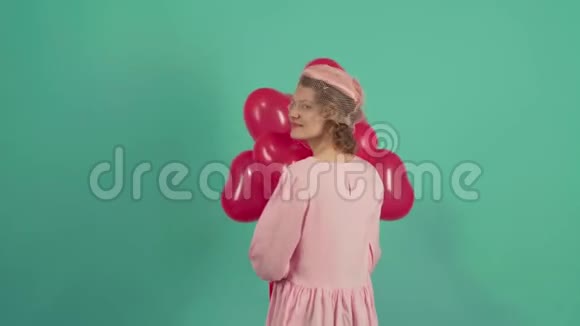 欢乐模特摆姿势玩得开心庆祝情人节情人节美女带着红色气球笑继续视频的预览图