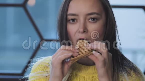 女人在午餐时吃华夫饼甜点享受和闭上眼睛视频的预览图