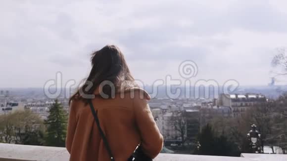后景年轻美丽体贴的旅游妇女观看华丽的巴黎全景在蒙马特的观点慢动作视频的预览图