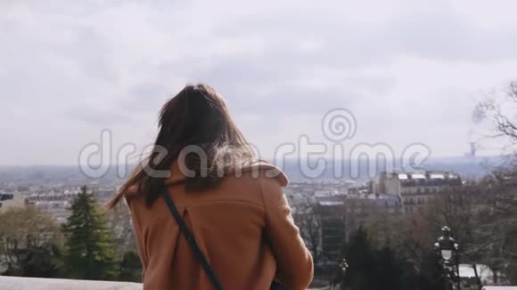 后景年轻美丽的摄影师女士拍摄阳光巴黎全景在蒙马特的观点慢动作视频的预览图