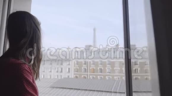 埃菲尔铁塔视图慢动作在窗前摆姿势的年轻快乐美丽女性博客作者的照片视频的预览图