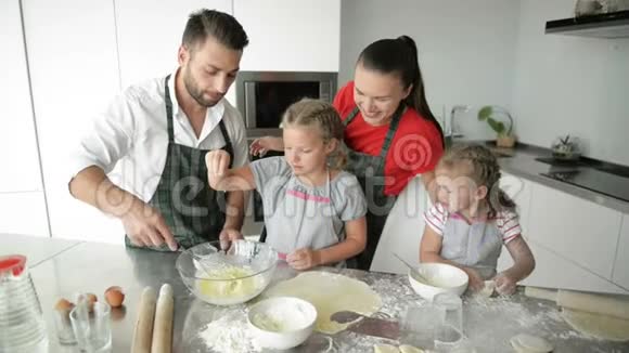 可爱的家庭一起做饭在厨房和现代的内部姐妹们乐于帮助父母视频的预览图
