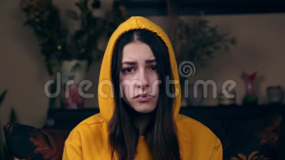 一个年轻悲伤的欧洲女孩坐在家里的扶手椅上竖起大拇指问喜欢社会化媒体视频的预览图