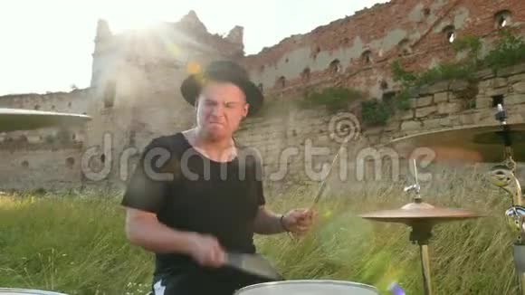 鼓手演奏鼓组和在一座被摧毁的建筑物附近的街道上视频的预览图