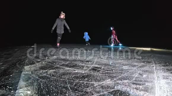 家人是滑冰之夜女孩和男孩在大自然中骑花样冰鞋母亲女儿和儿子视频的预览图