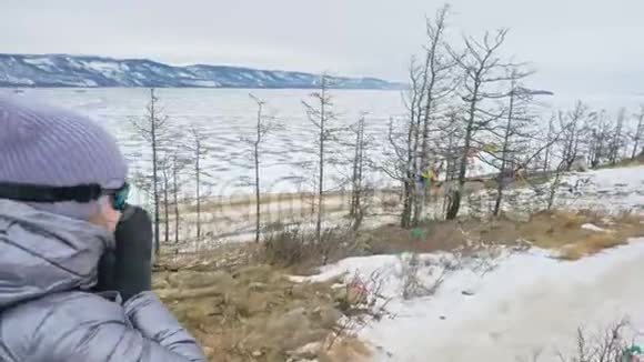 贝加尔湖冰上女子旅行佛教佛塔伯汗纪念塔象征神秘的历史仪式视频的预览图