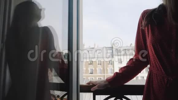 在法国阳台的窗口欣赏埃菲尔铁塔景的慢动作穿着红色裙子的美丽女子的特写幻灯片视频的预览图