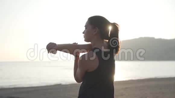 女孩在户外运动前热身日落时肌肉伸展视频的预览图