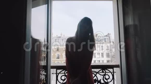 快乐轻松的白人美女博主微笑着在房间阳台上摆姿势浪漫的埃菲尔铁塔观巴黎慢动作视频的预览图