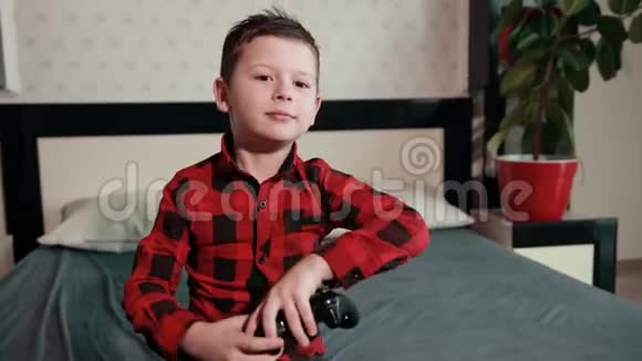 可爱的男孩玩电子游戏拿着操纵杆有感情的时间视频的预览图