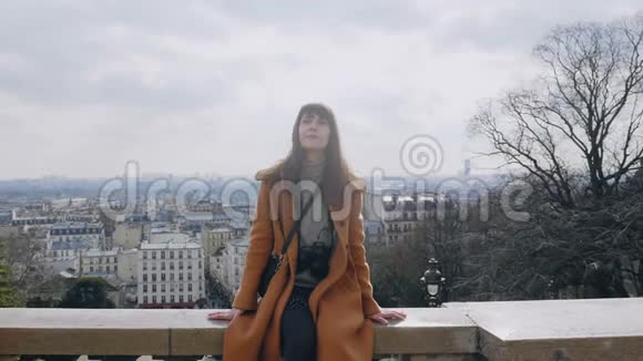 放大年轻美丽的摄影师妇女坐在巴黎全景在蒙马特观点慢动作视频的预览图