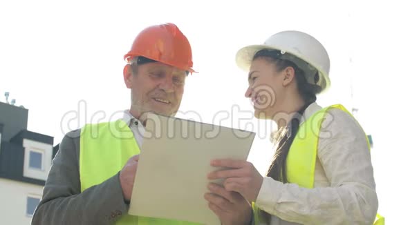 两个建筑工人一个男人和一个年轻的女人正在讨论工作问题好心情视频的预览图