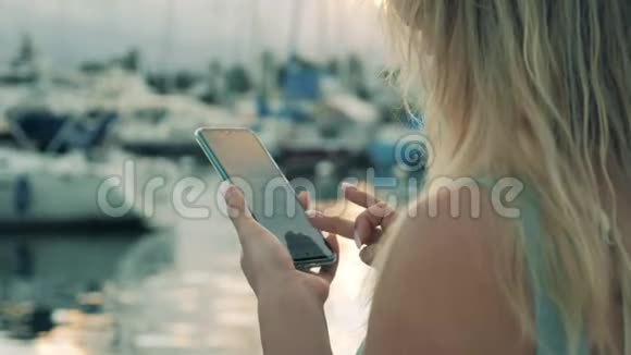 女人站在靠近水的码头用电话工作视频的预览图