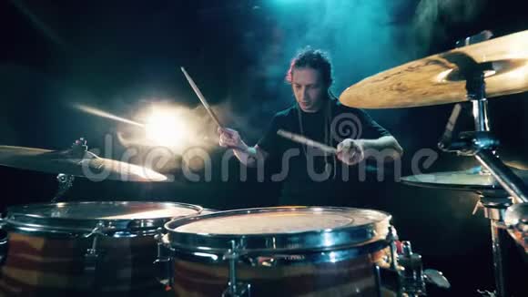 鼓组鼓包在黑暗中鼓手演奏音乐会一个男人正在用鼓包排练视频的预览图
