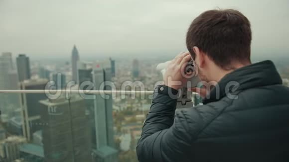 一个大城市的城市景观是人通过放大装置单眼观察的视频的预览图