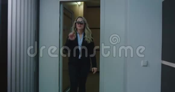 办公室走廊上戴VR眼镜的女商人视频的预览图