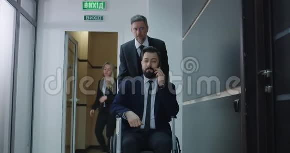 轮椅经理在办公室走廊打电话视频的预览图