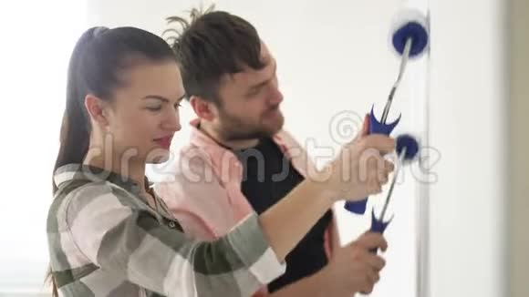 年轻夫妇装饰他们的新公寓年轻的夫妻正在粉刷墙壁一对漂亮的夫妇正在修理视频的预览图