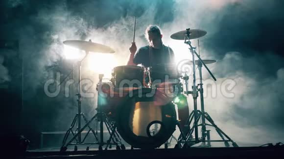 黑暗的工作室白烟和一个人打鼓鼓组鼓包在黑暗中鼓手演奏音乐会视频的预览图