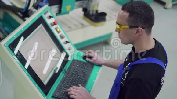 一名男性数控机床操作员正在控制面板上打字视频的预览图